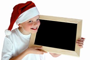 Christmas Message: Child with a Christmas hat holding a chalk board isolated over white