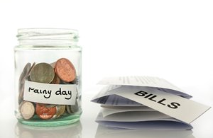 Rainy Day Savings: Clear glass jam jar with coins inside savings concept