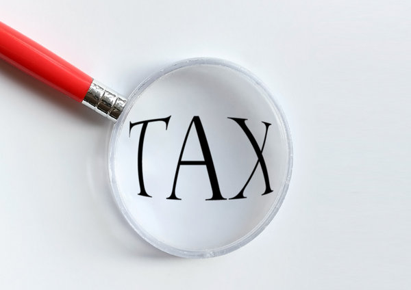 Tax: Magnifying glass over the word tax