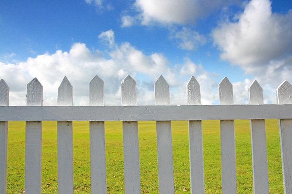 Picket Fence: A white wooden picket fence against a blue sky