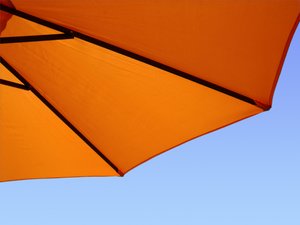 Sunny umbrella: orange beach umbrella in blue sky