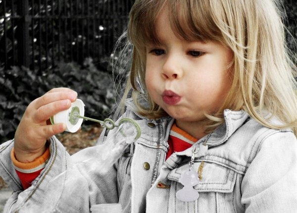 Blowing bubbles: Small girl blowing bubbles.

